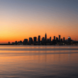 Coastal city skyline at dusk reflecting on a tranquil harbor.
